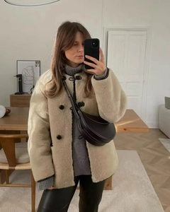 Selfie miroir montrant une veste beige en fausse fourrure et un pantalon en cuir noir
