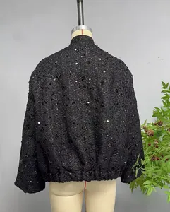 Detailed back view of a black sequin cropped jacket with elastic hem and thick tweed texture