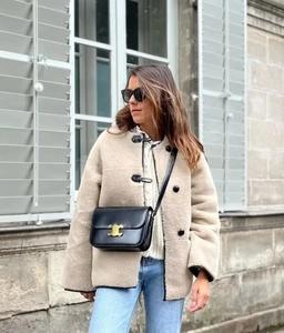 Détail d'un manteau en fausse fourrure crème pour femme avec sac à bandoulière chic