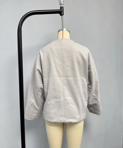 Détail arrière d'un manteau en laine gris clair style kimono avec couture minimaliste