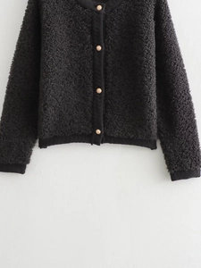 Detailed view of the black textured knit cardigan featuring four gold embossed buttons