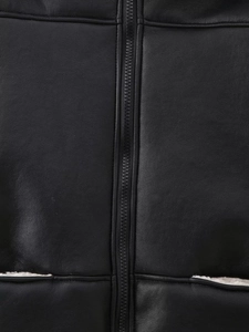 Détail de la veste en cuir noir avec fermeture éclair et doublure en peau de mouton blanche