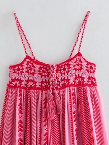 Detail of bohemian crochet knit floral patterns and tassel ties on the pink dress