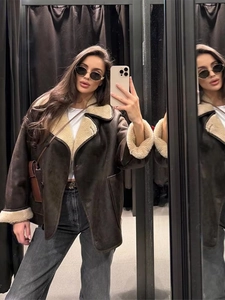 Close-up of women's shearling pilot jacket with white fleece collar and brown suede