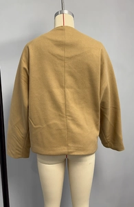 Détail de la couture arrière et texture de laine sur une veste courte camel