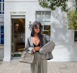 Détail de la veste oversize en laine grise avec sac à main en cuir de luxe et fermoir doré