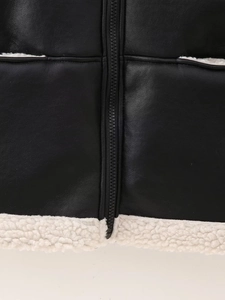 Détail de la veste en cuir noir avec doublure en peau de mouton blanche et fermeture éclair