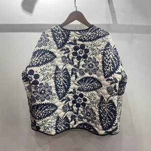 Quilted floral jacket with blue botanical print and black piping on white cotton fabric