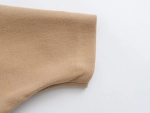 Detailed close-up of camel wool blend coat featuring premium twill texture and smooth finish