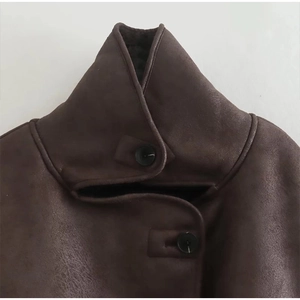 Detail of high neck dark brown faux suede jacket with plush lining and black buttons