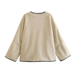 Détail du dos de la veste en fausse fourrure beige avec bordures noires contrastées