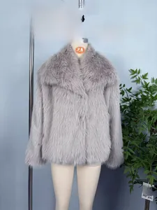 Détail d'un manteau en fausse fourrure gris clair avec col en peluche et poils longs