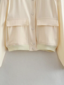 Detail of off-white bomber jacket featuring large utility pockets and a ribbed hem