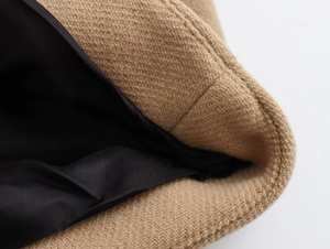 Macro view of camel wool blend fabric with twill texture and black satin lining finish