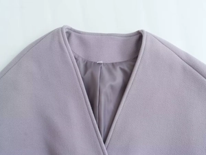 Détail du manteau en laine violette avec coupe en V et doublure en satin lisse et soyeux