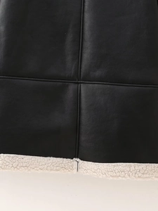 Détail d'une veste en cuir noir avec surpiqûres et doublure en fausse peau de mouton