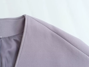 Gros plan du manteau en laine lavande montrant les coutures et la doublure en soie
