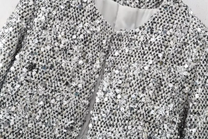 Detailed macro of tweed fabric with shimmering silver sequins and white inner lining