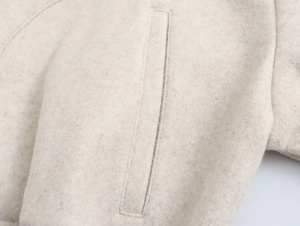 Nahaufnahme der Jacke aus Wollmischung mit weicher Textur und vertikaler Leistentasche