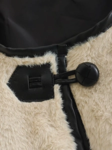Détail d'un manteau en fausse fourrure avec liserés en cuir noir et bouton rond