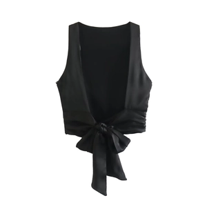 Detail of a black satin sleeveless crop top featuring a large back bow and open back design