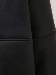 Gros plan des coutures et de la texture fine du cuir noir de la veste décontractée
