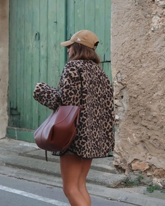 Détail d'une veste en polaire léopard assortie à un grand sac cabas en cuir marron