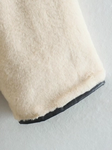 Détail du manteau en fausse fourrure blanche avec bordure en cuir noir élégante