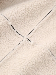 Détail de la doublure en peau lainée beige avec des coutures en croix noires de qualité