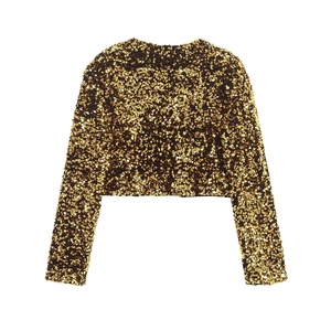 Detalle del bolero de lentejuelas doradas con textura metálica y manga larga