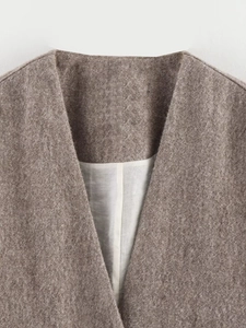 Detailed close-up of V-neck collar and thick wool texture on dark beige winter coat
