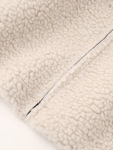 Gros plan sur la texture sherpa blanc cassé et les détails de couture premium