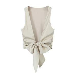 Detail of champagne satin vest showing the large center bow and smooth silky texture