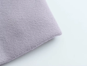Gros plan sur un tissu en laine lavande doux montrant la texture et le pliage fini