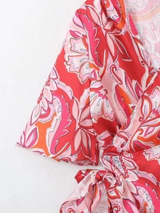 Gros plan sur le tissu à imprimé floral bohème avec manche cloche et lien à nouer