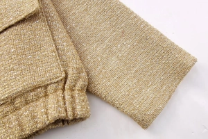 Close-up of gold sequin tweed jacket featuring metallic thread and pocket details