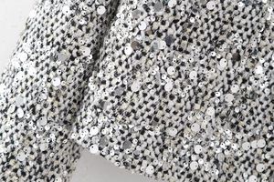 Detail of tweed fabric texture with silver sequins on round neck jacket for women