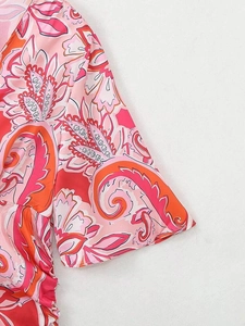 Gros plan détaillé de l'imprimé floral paisley rose et orange sur la manche de la robe