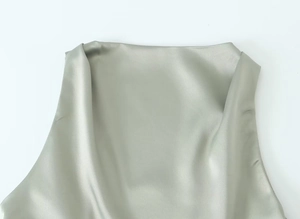 Detailed close-up of sage green satin fabric texture and cowl neck on sleeveless top