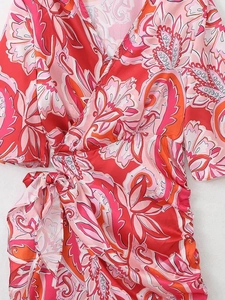 Détail de la robe portefeuille à fleurs roses avec col en V et élégant lien à la taille