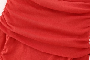 Detail of red knit fabric featuring ribbed texture and elegant ruched pleat design