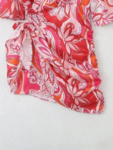 Détail d'une mini robe cache-cœur à imprimé paisley avec nouage latéral et fronces