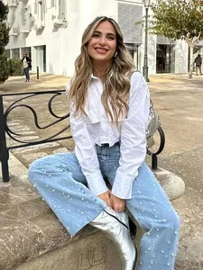 Vue street style d'une chemise blanche à col POLO et d'un jean en denim orné de perles