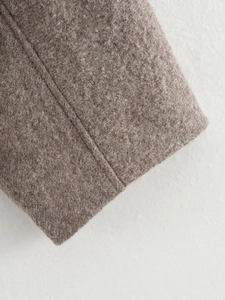 Macro view of wool fabric texture and neat double-stitching on a winter coat sleeve