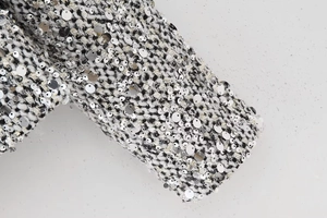 Macro shot of sequined tweed fabric detail with silver sequins on black and white texture