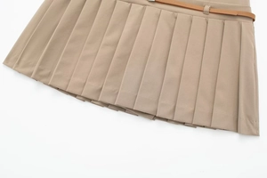 Dettaglio della gonna a pieghe kaki con sottile cintura in pelle marrone e fibbia