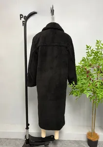 Détail de la texture épaisse d'un long manteau noir en polaire et fausse fourrure