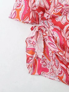 Gros plan sur l'imprimé floral tropical avec nœud latéral et détails de robe portefeuille