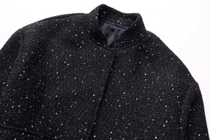 Detail of black sequined tweed jacket collar with stand-up neck and metallic shimmer texture