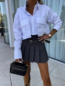 Détail d'une chemise courte blanche à manches longues avec grandes poches et col polo